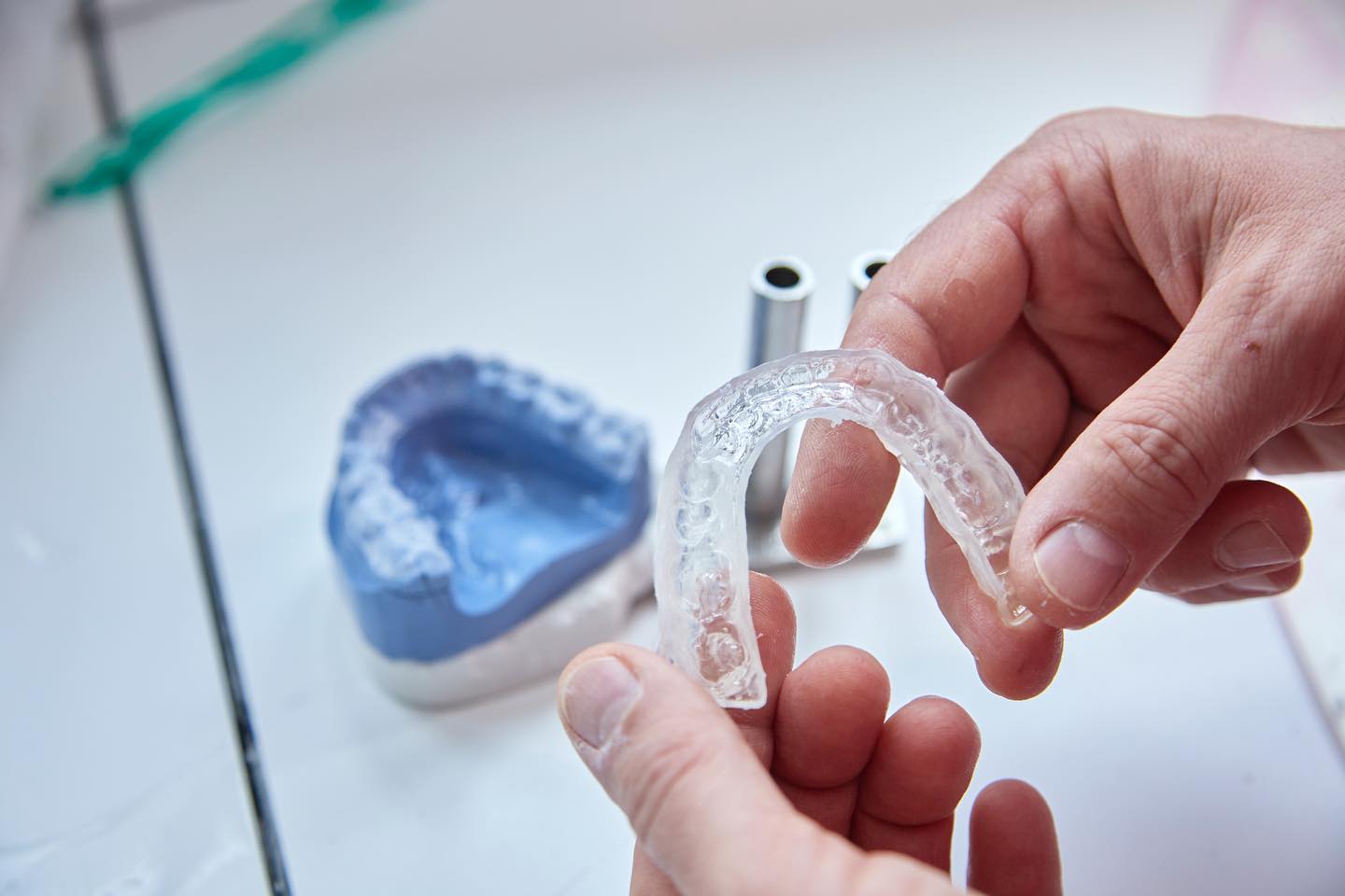 Nahaufnahme einer transparenten Zahnschiene, die mit der Hand gehalten wird.