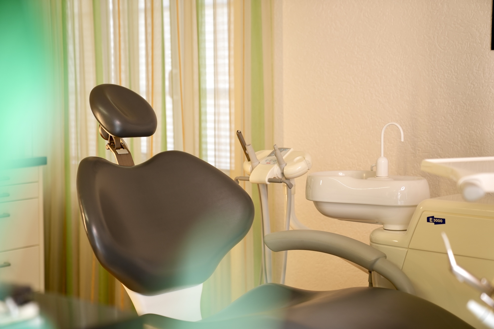 Kieferorthopädischer Behandlungsraum mit braunem Behandlungsstuhl.